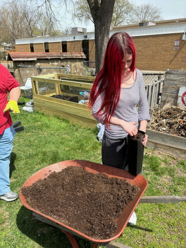 A student at Shabazz City High School planting trees.